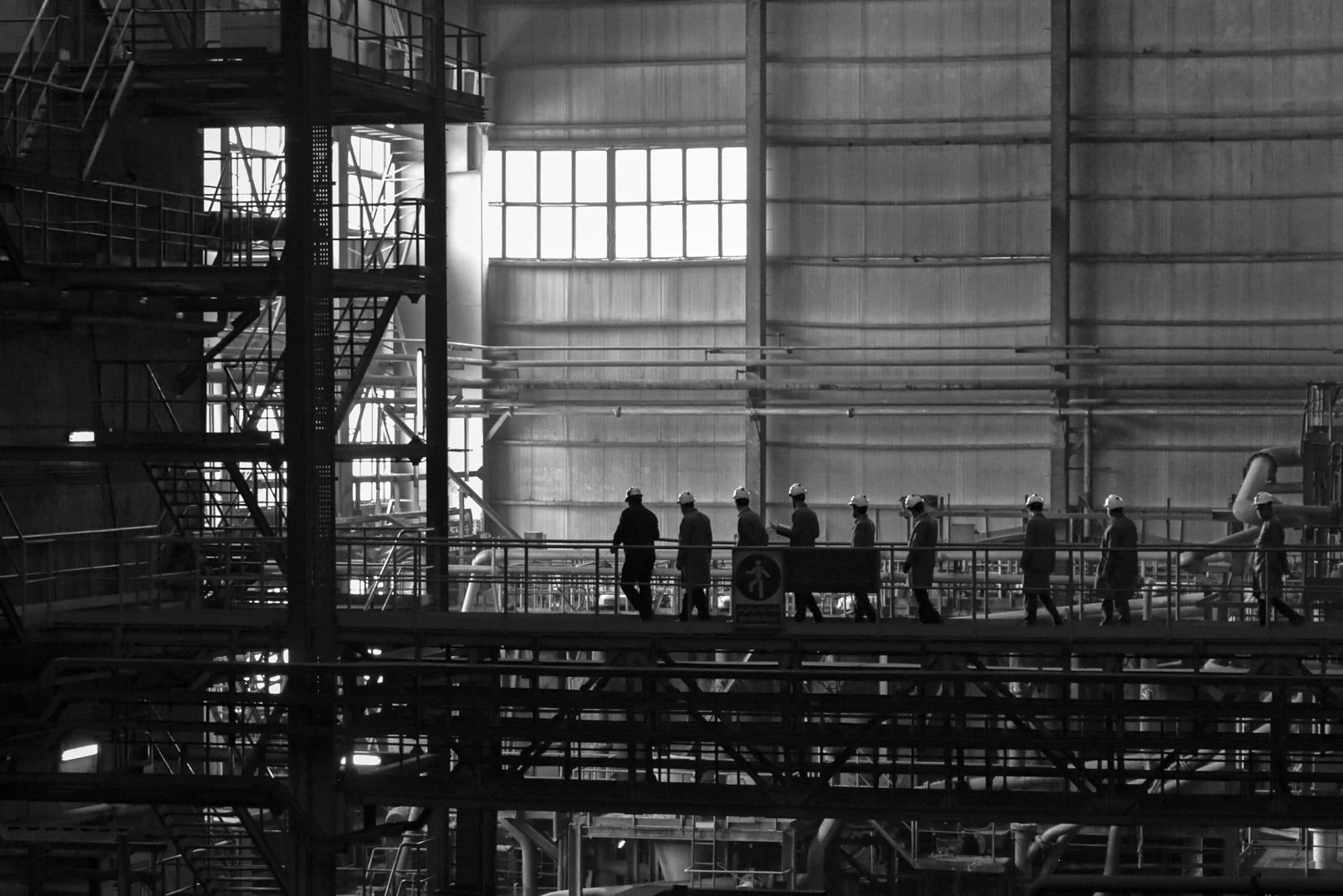 Team crossing a walkway during a walkdown of an industrial hall